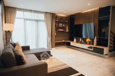 Spacious modern living room with large sofa and entertainment center.