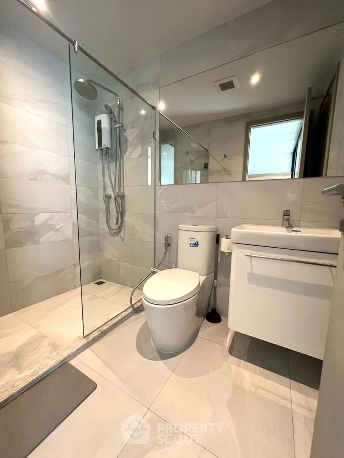 Modern bathroom with glass shower and sleek fixtures in contemporary home.
