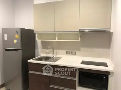 Modern kitchen with sleek cabinets, stainless steel fridge, and built-in appliances.
