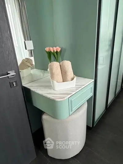 Chic bedroom corner with elegant vanity and fresh tulips, perfect for modern living.
