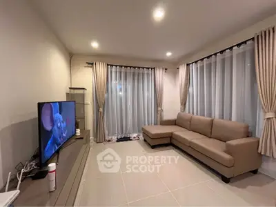 Modern living room with sleek furniture and large windows for natural light.