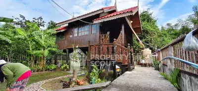 Charming traditional wooden house with lush garden and elevated design in serene setting.