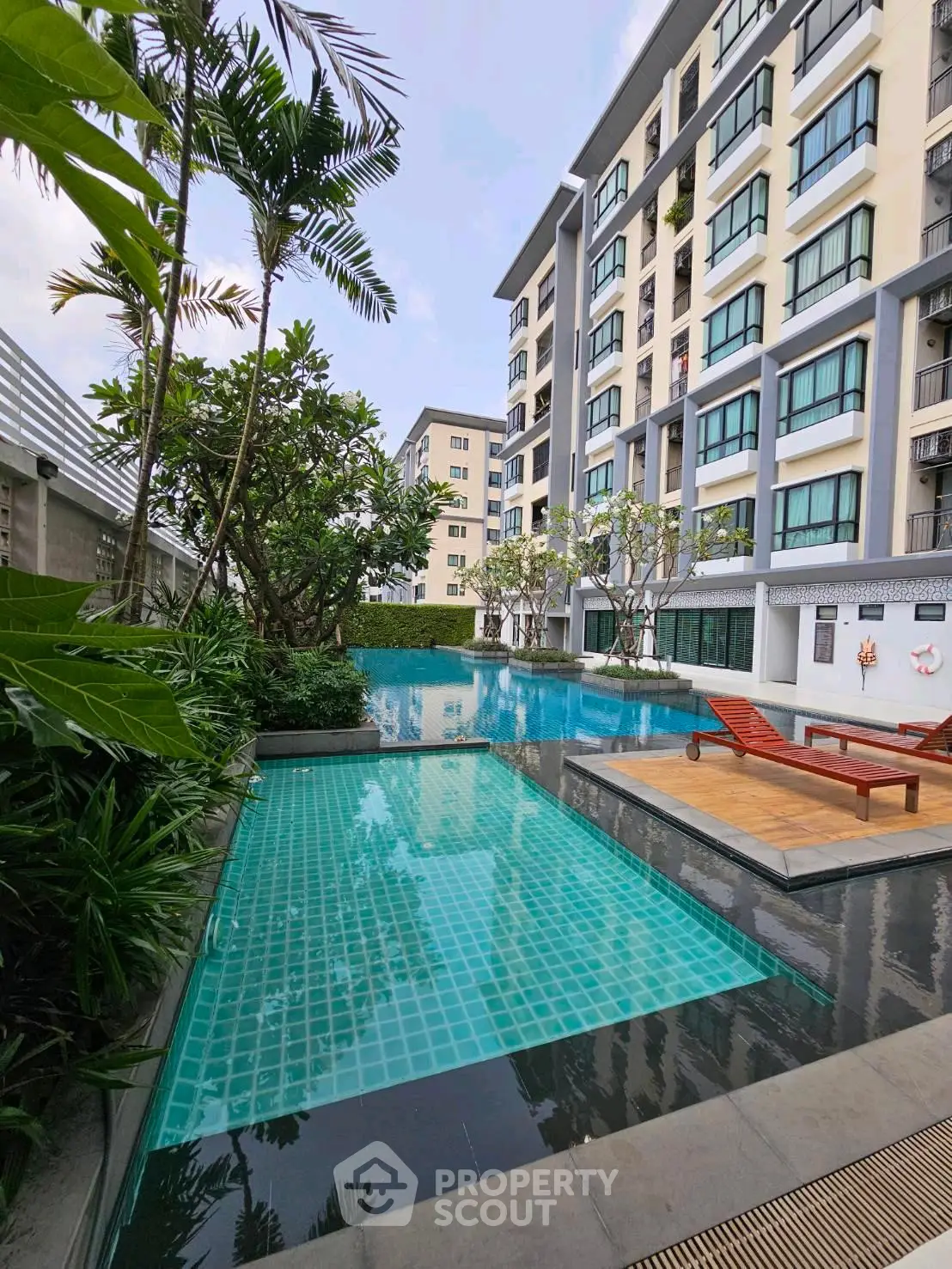 Luxurious condominium with stunning pool and lush greenery, perfect for relaxation and leisure.