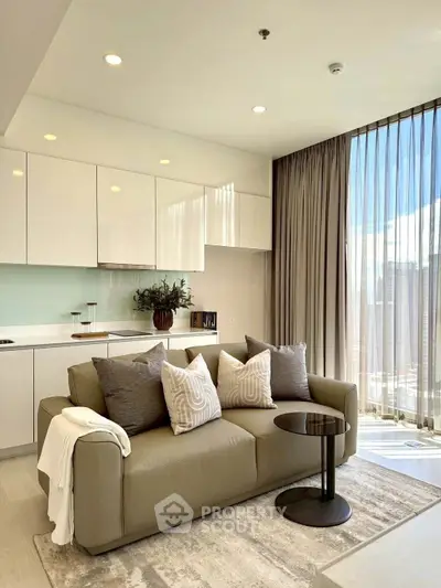 Modern living room with sleek kitchen, cozy sofa, and floor-to-ceiling windows offering abundant natural light.