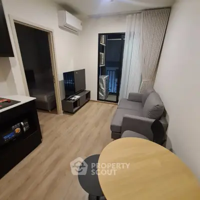 Modern living room with sleek furniture and balcony access in a stylish apartment.