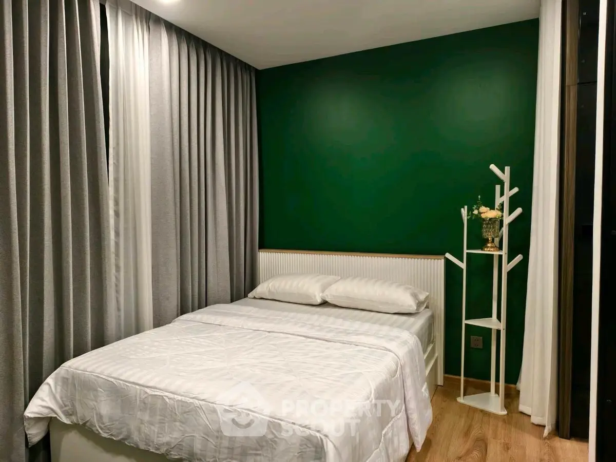 Cozy bedroom with green accent wall and modern decor