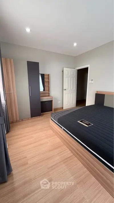 Spacious bedroom with modern furnishings and natural light, perfect for relaxation and comfort.
