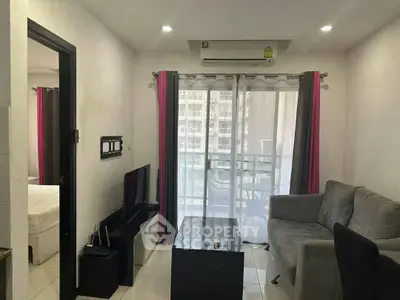 Cozy living room with modern furniture and balcony access in urban apartment.