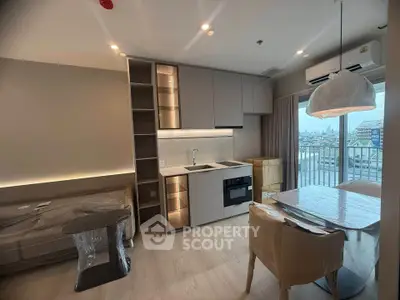Modern apartment interior with open kitchen and city view balcony.