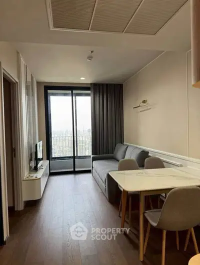 Modern living room with balcony view, featuring sleek furniture and elegant decor.