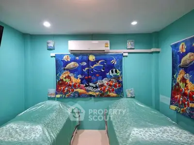 Vibrant aquatic-themed room with twin beds and air conditioning, perfect for a unique stay.