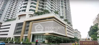 Modern high-rise building with lush greenery and elegant architecture in urban setting.