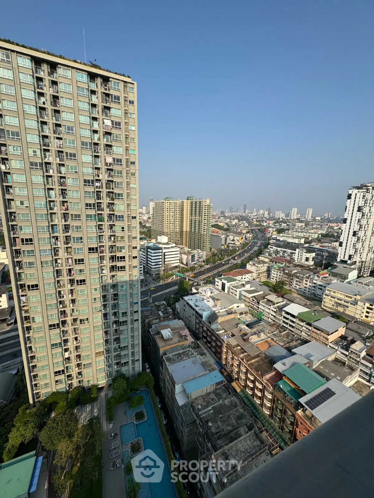Stunning cityscape view from high-rise apartment with pool and urban skyline.