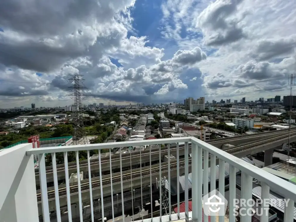 Stunning cityscape view from a high-rise balcony with expansive skyline and dynamic clouds.