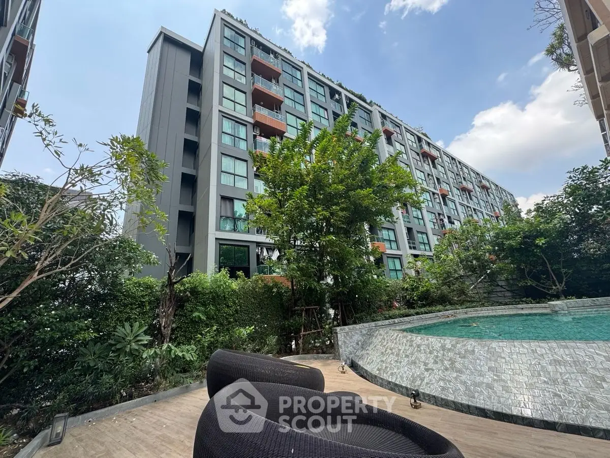Modern condominium with poolside view and lush greenery, perfect for urban living.