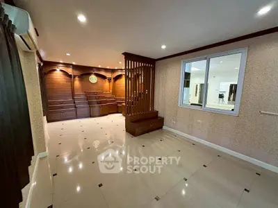 Spacious living room with elegant wood paneling and modern lighting