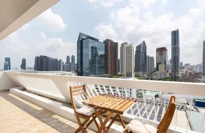 Stunning cityscape view from a spacious balcony with modern seating area.