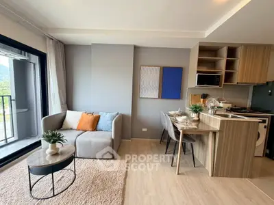 Modern living room with open kitchen and balcony view, featuring stylish decor and cozy seating area.