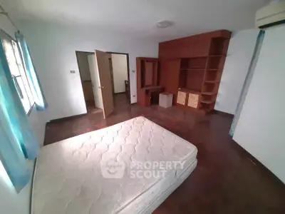 Spacious bedroom with natural light and built-in wooden storage