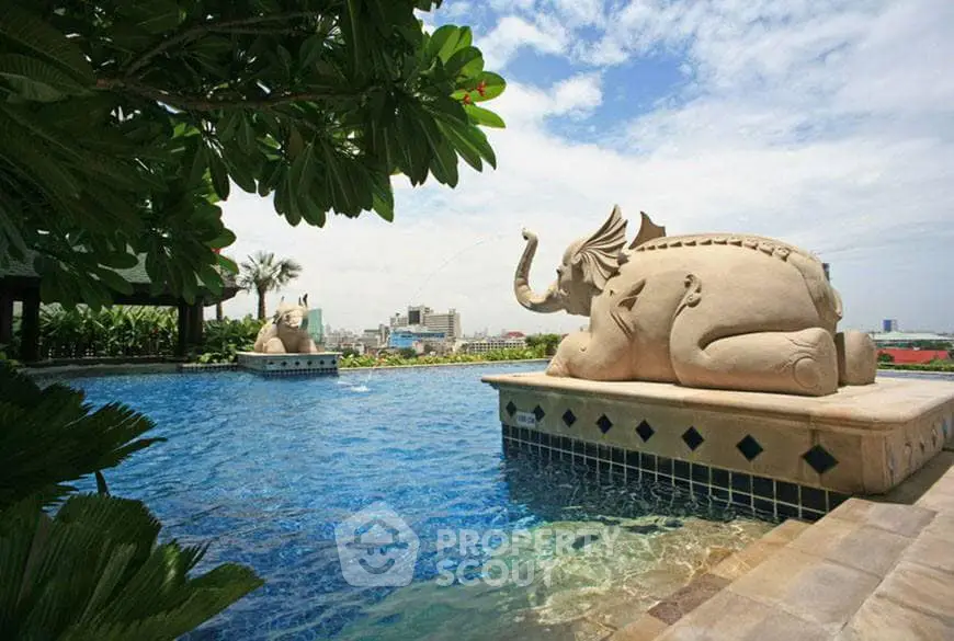 Luxurious resort-style pool with an impressive elephant sculpture, surrounded by lush greenery and a serene ambiance, perfect for high-end real estate listings.