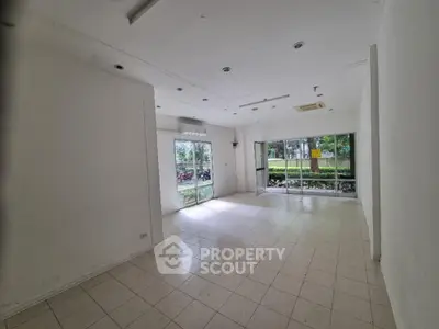 Spacious empty room with large windows and tiled floor, ideal for customization.