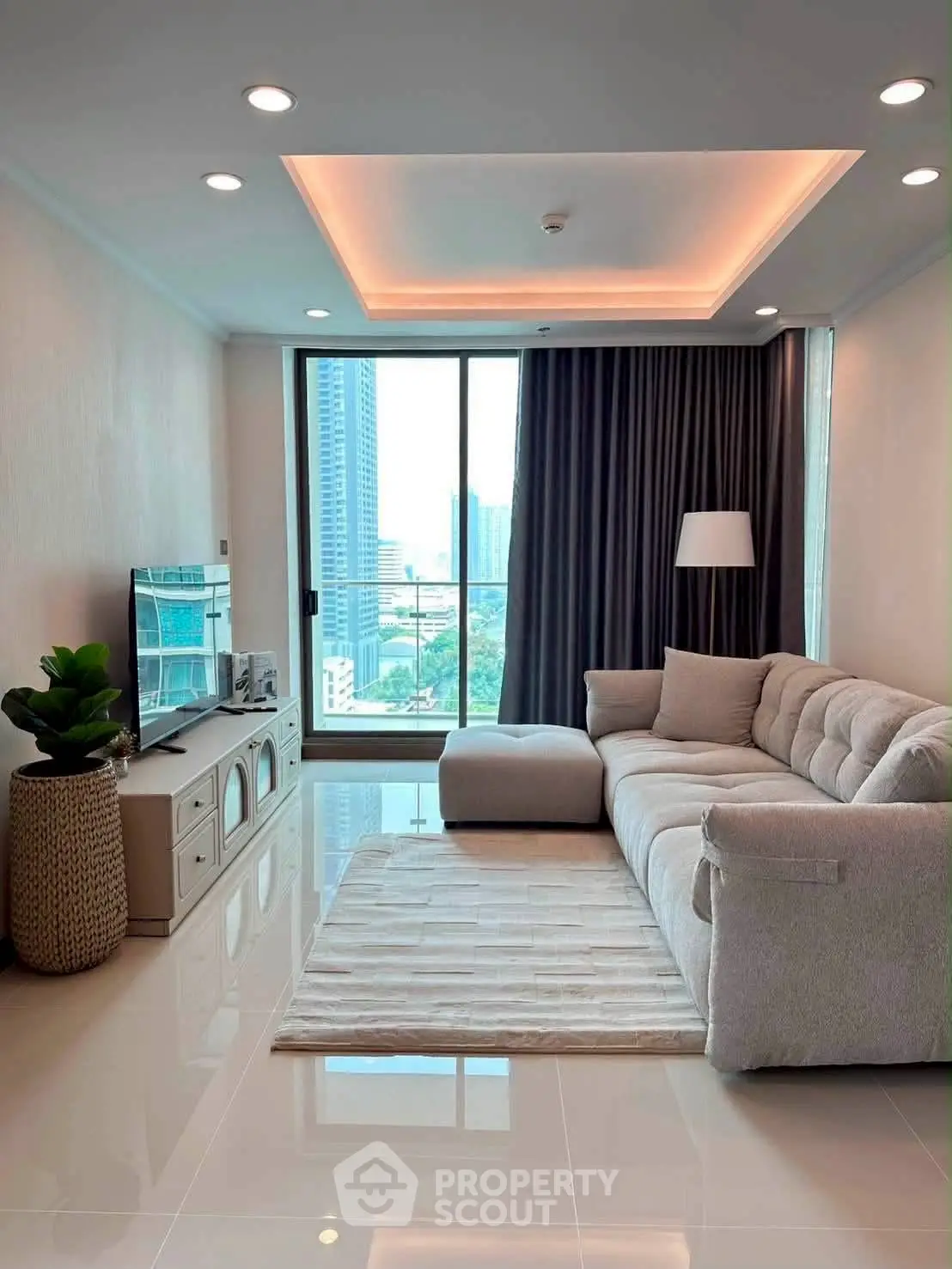 Modern living room with plush sofa and city view from large window, perfect for urban living.