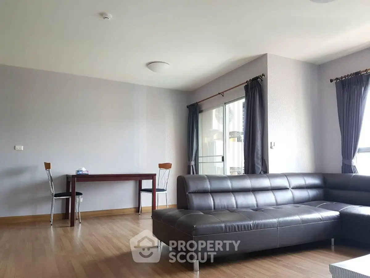 Spacious modern living room with sleek leather sofa and elegant dining area.