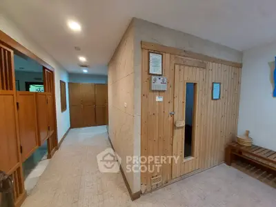 Spacious sauna room in modern wellness facility with wooden interior and seating area.