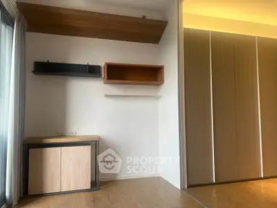 Modern minimalist interior with wooden flooring and built-in shelves, perfect for a stylish living space.