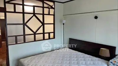 Spacious bedroom with unique wooden partition and cozy lighting