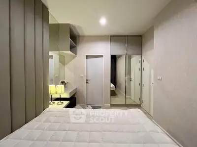 Modern bedroom with sleek design, mirrored wardrobe, and cozy lighting in a stylish apartment.