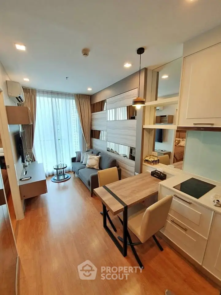 Modern living room with open kitchen, stylish decor, and natural light in a cozy apartment.