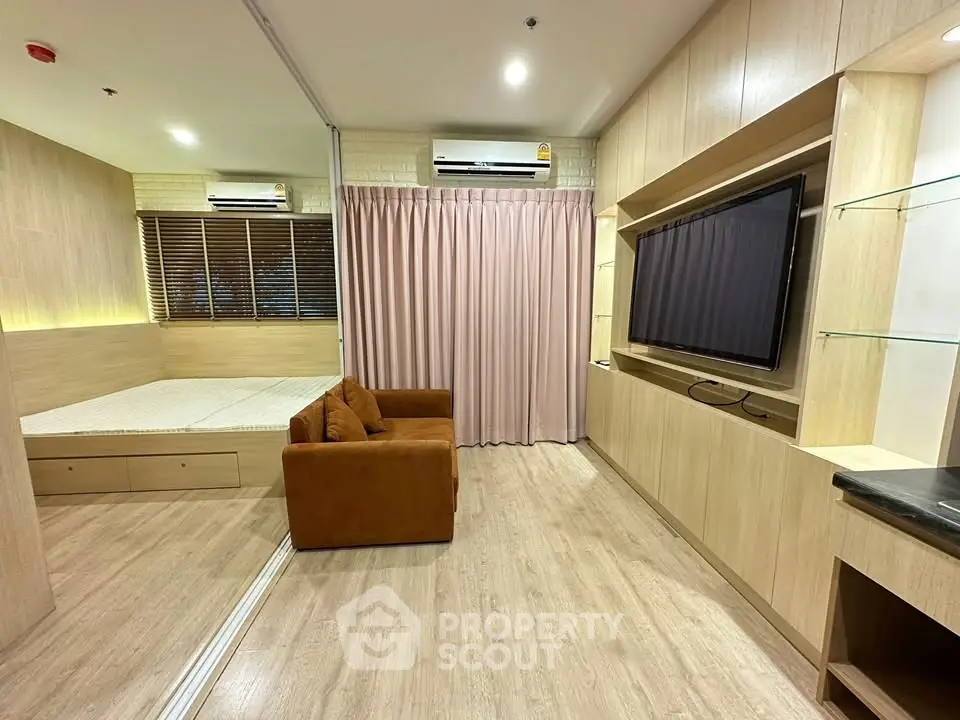 Modern studio apartment with cozy living area and built-in TV unit