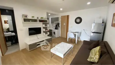Modern living room with open kitchen, featuring stylish decor and appliances, perfect for urban living.