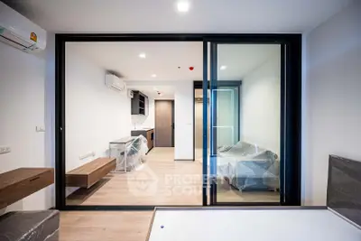 Modern apartment interior with sliding glass doors and wooden flooring