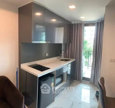 Modern kitchen with sleek cabinetry and balcony view in stylish apartment