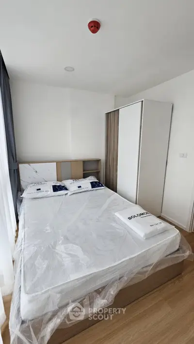 Modern bedroom with minimalist design featuring a cozy bed and sleek wardrobe.