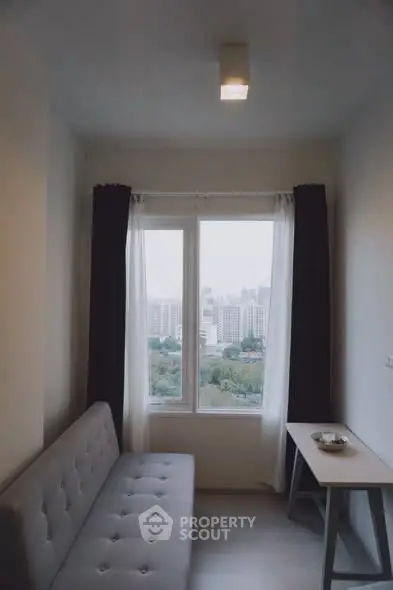 Cozy small living room with city view through large window