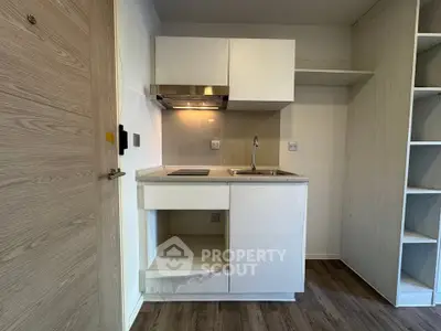 Compact modern kitchen with sleek cabinetry and built-in appliances in a cozy apartment.