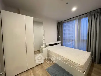 Modern bedroom with large window and minimalist furniture in a stylish apartment.
