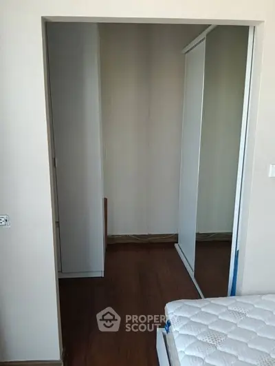 Spacious bedroom with mirrored wardrobe and wooden flooring, perfect for modern living.