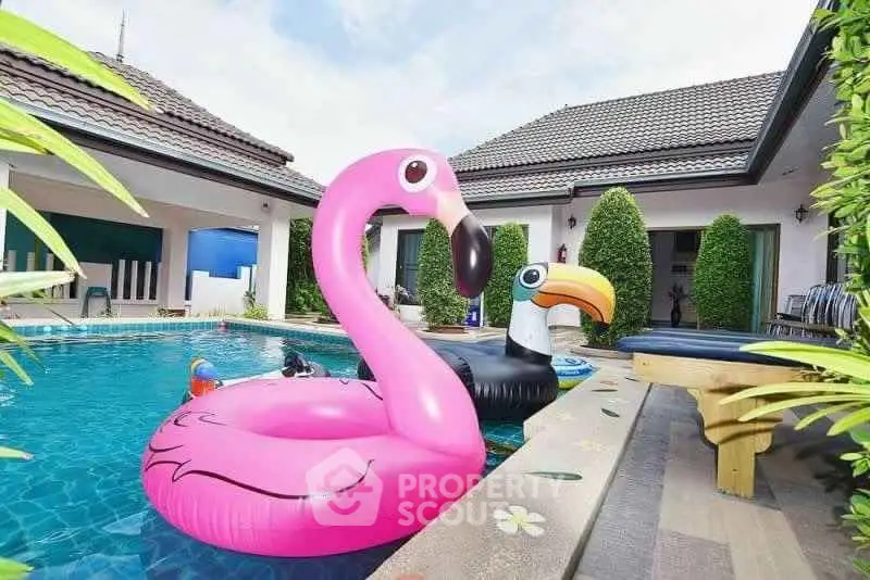 Luxurious villa with private pool and playful inflatables, perfect for relaxation and entertainment.