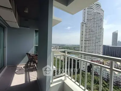 Stunning balcony view with modern high-rise buildings and clear blue sky.