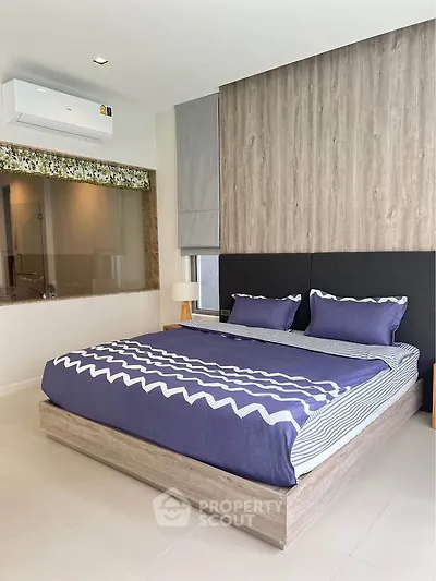 Modern bedroom with stylish decor and air conditioning in a contemporary apartment.