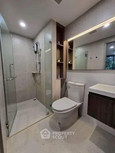 Modern bathroom with glass shower and sleek fixtures in a contemporary apartment.