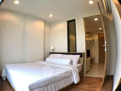 Cozy bedroom with wooden flooring and modern lighting in a stylish apartment.