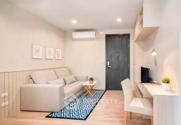 Modern living room with cozy sofa, stylish decor, and workspace in a bright apartment.