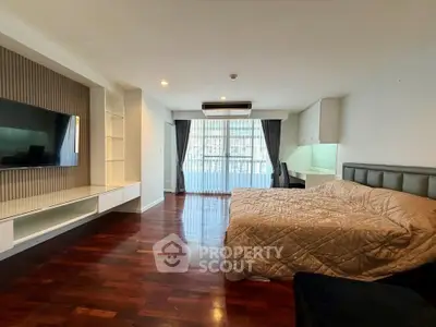 Spacious bedroom with modern decor and large window offering natural light