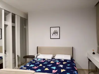 Modern bedroom with stylish decor and mirrored wardrobe doors.