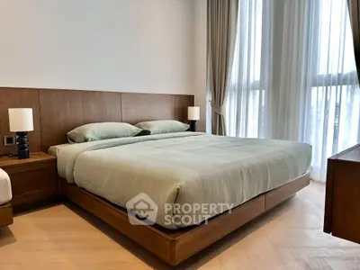 Spacious bedroom with modern wooden furniture and large windows for natural light.